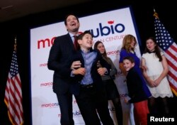 Republican U.S. presidential candidate Senator Marco Rubio holds one of his sons after speaking to supporters at the Rubio caucus watch party at the Downtown Marriott Hotel in Des Moines, Iowa, Feb. 1, 2016.