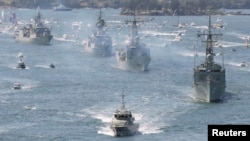 FILE - Royal Australian Navy warships led by HMAS Sydney (R) enter Sydney Harbor as part of the International Fleet Review celebrations October 4, 2013. 