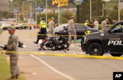 A damaged police motorcycle rests in the intersection after a vehicle crashed into a crowd of spectators during the Oklahoma State University homecoming parade, causing multiple injuries and deaths, in Stillwater, Okla., Oct. 24, 2015.