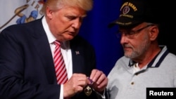 Ông Trump nhận huân chương Anh dũng Bội tinh của Trung tá hồi hưu Louis Dorfman trong một cuộc tụ họp ở Ashburn, Virginia, 2/8/2016.