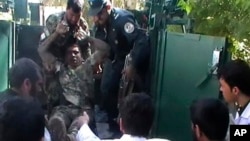 Injured Afghan National Army soldier removed from military vehicle outside local hospital following courthouse attack in Farah province, April 3, 2013.