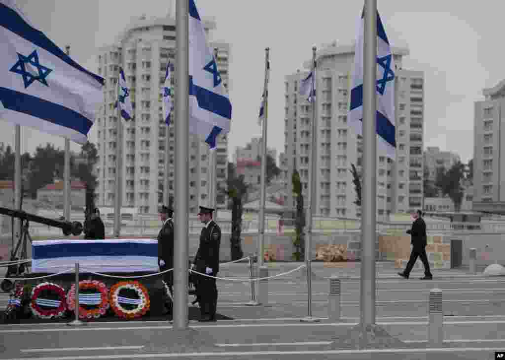 Para anggota pasukan keamanan berjaga dekat peti jenazah mantan perdana menteri Israel Ariel Sharon di Plaza Knesset Plaza, Yerusalem (12/1). (AP/Oded Balilty)