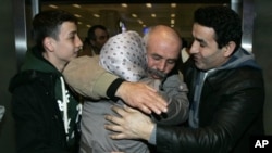 A Turkish man, second from right, greets family members after arriving in Turkey from Libya February 22, 2011.