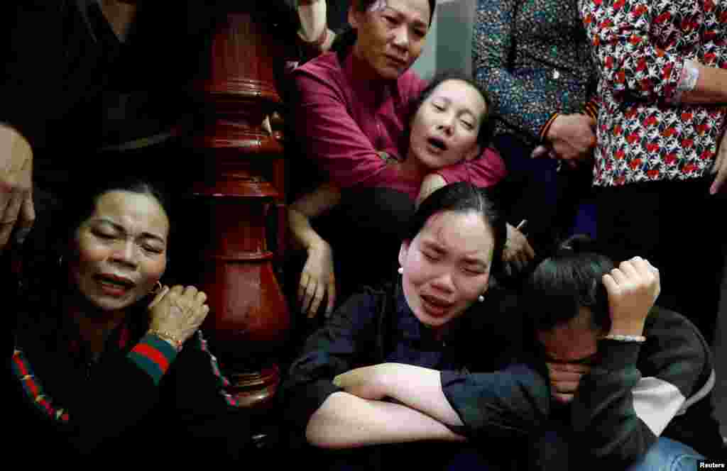 Relatives of John Hoang Van Tiep, a victim who was found dead in the back of a British truck last month, mourn during his funeral in Nghe An province, Vietnam.