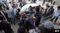 Người biểu tình đưa một người bị thương ra khỏi nơi xảy ra xô xát với lực lượng an ninh, trong thủ đô Sana'a, Yemen, hôm 24/12/11