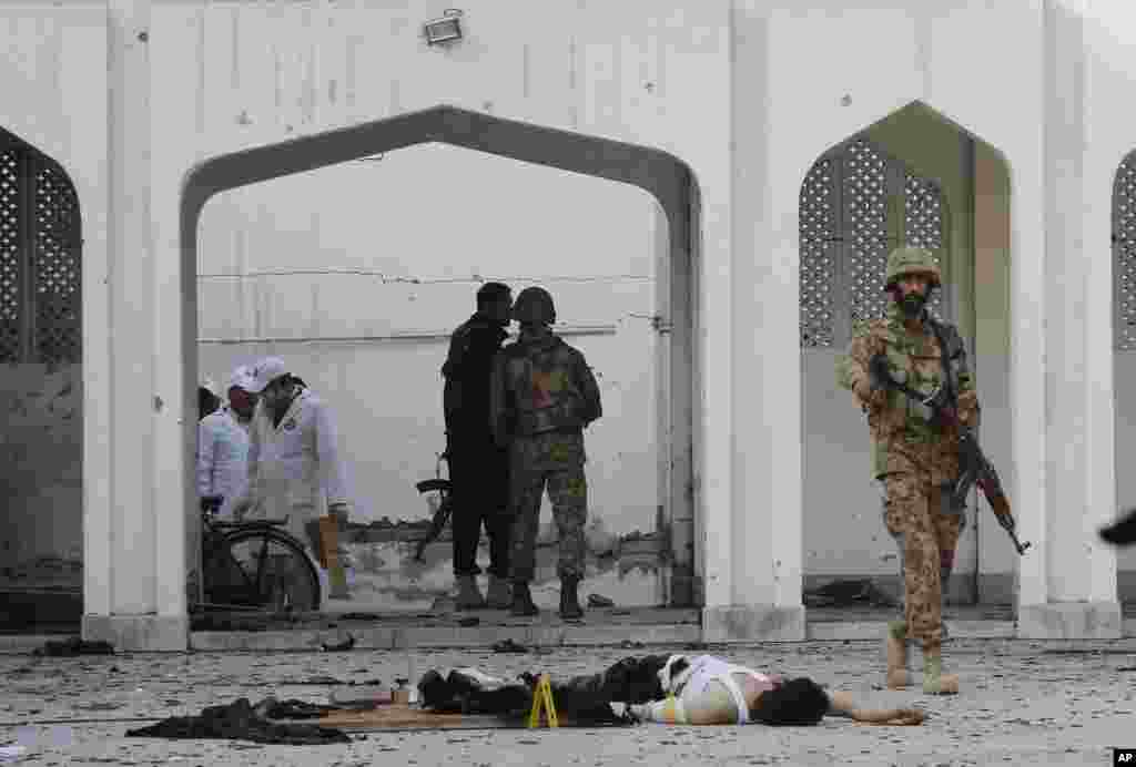A Pakistani soldier walks past a body of a suicide bomber killed by security forces during an attack&nbsp; on a Shi&#39;ite mosque in Peshawar, Feb. 13, 2015.