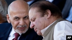 FILE - Afghan President Ashraf Ghani (l) talks with Pakistani Prime Minister Nawaz Sharif in Islamabad, Pakistan. After a recent brutal bombing in Kabul that killed 64 people and wounded 340, an outraged Ghani said he was no longer interested in Pakistan’s help to bring the Taliban to the negotiating table and instead he wanted Pakistan to launch an all-out operation against the Haqqani network on its territory. 