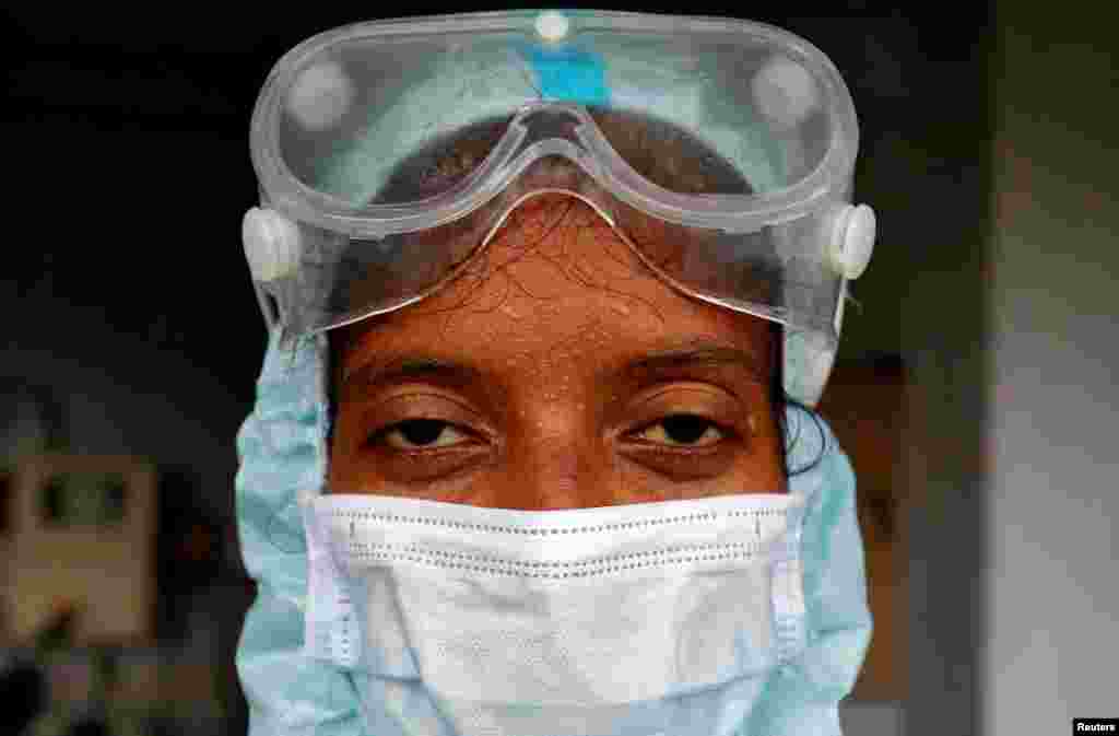 Beads of sweat run down the forehead of a healthcare worker wearing protective gear at a residential apartment in Ahmedabad, India.