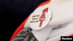 Sebuah lencana bertuliskan "Kekuatan Pekerja Menentang Khitan Perempuan," dikenakan seorang relawan konferensi Hari Penghapusan Khitan Perempuan Internasional di Kairo, Mesir, 6 Februari 2018.