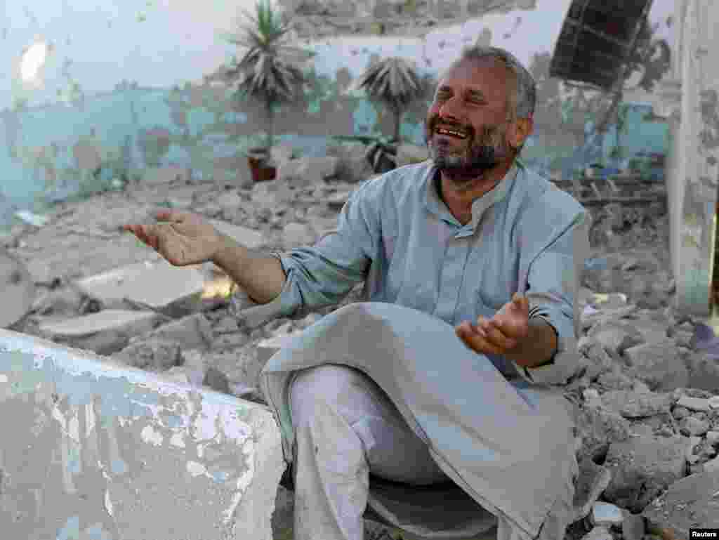 Seorang pria meratapi kehancuran setelah serangan udara di Azaz, dekat Aleppo (15/8).