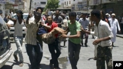 Anti-government protesters carry a fellow protester wounded during clashes with police in the southern Yemeni port city of Aden, April 30, 2011