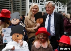 Actress Joely Richardson (C) stands with Alf Dubs and demonstrators portraying Paddington Bear, during a protest highlighting the plight of child refugees, outside the Home Office in London, Oct. 24, 2016.
