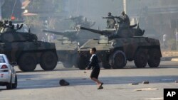 FILE: Military tanks patrol in Harare following demonstrations by opposition party supporters in the capital, Wednesday, Aug. 1, 2018. Gunfire, tear gas, and burning cars disrupted Harare’s streets Wednesday as armed riot police and army troops clashed with rock-throwing opposition supporters, protesting delays in announcing the results of Monday’s presidential election, the first after the fall of longtime leader Robert Mugabe. (AP Photo/Tsvangirayi Mukwazhi)