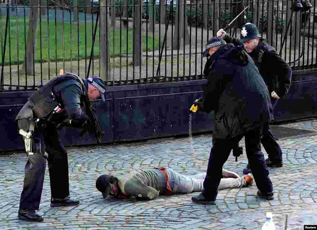 Armed police taser a man inside the grounds of the Houses of Parliament in London, Britain, December 11, 2018.