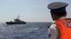 FILE - A Vietnamese coast guard officer looks at a Vietnamese coast guard vessel in the South China Sea, May 14, 2014. Vietnam has faced increasingly aggressive Chinese territorial claims to sections of the South China Sea, where Vietnamese maritime patrols have faced off against Chinese naval forces.