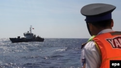 FILE - A Vietnamese coast guard officer looks at a Vietnamese coast guard vessel in the South China Sea, May 14, 2014. Vietnam has faced increasingly aggressive Chinese territorial claims to sections of the South China Sea, where Vietnamese maritime patrols have faced off against Chinese naval forces.