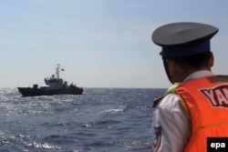 FILE - A Vietnamese coast guard officer looks at a Vietnamese coast guard vessel in the South China Sea, off the shore of Vietnam, May 14, 2014.