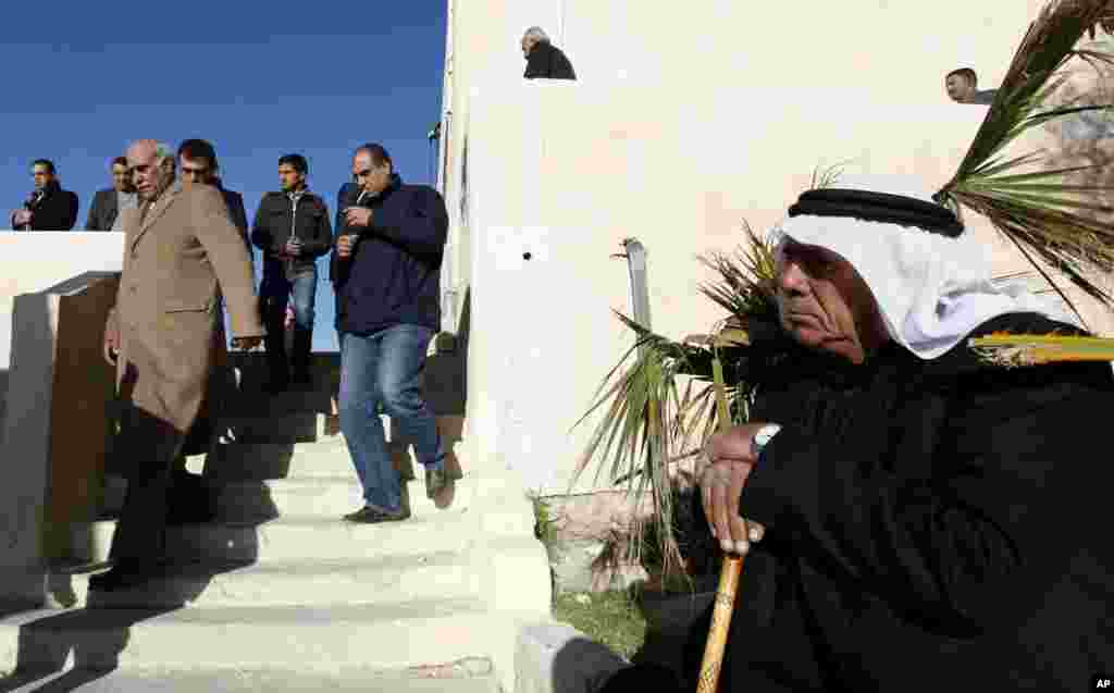Parliamentary candidate Mahmoud al Kharabshy, left, arrives at his district polling station to observe the voting process in Al-Salt, Jordan, January 23, 2013.