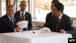 Donald Trump razgovara sa japanskim premijerom Shinzo Abeom tokom ručka u Kasumigaseki kantri klubu pokraj Tokija. Predsjednik i premijer potpisali su se na kape na kojima piše "Donald i Shinzo prave savezništvo još većim".