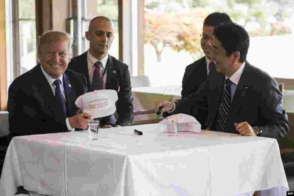 Presiden Donald Trump berbincang dengan Perdana Mentari Shinzo Abe dalam jamuan makan siang di Kasumigaseki Country Club Gold Course di Tokyo, 5 November 2017.