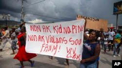 Gente protesta con una pancarta que dice en creole "No a los secuestros, no a la violencia contra las mujeres. Viva Christian Aid Ministries". Reclama la libertad de misioneros secuestrados en Titanyen, al norte de Puerto Principe, el 19 de octubre de 2021. 