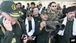 In this photo released by the semi-official Iranian Fars News Agency, Iranian Revolutionary Guard commander Mohammad Ali Jafari, center, monitors maneuvers by the Iranian Revolutionary Guard, near the Strait of Hormuz, 24 Apr 2010