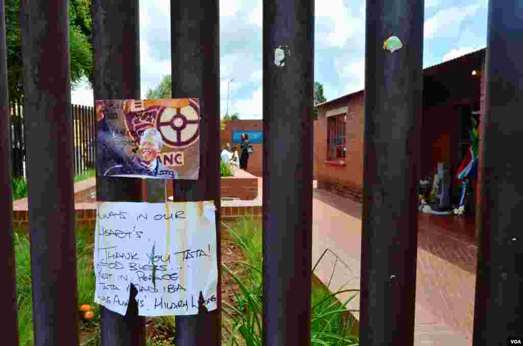 A card and note hang on the fence surrounding the Nelson Mandela National Museum, Mandela&#39;s former home, in Soweto, Dec. 12, 2013. (Peter Cox for VOA) 