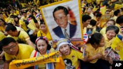 FILE - Supporters of Thailand's King Bhumibol Adulyadej, carrying portraits and banners, are seen celebarting his 87th birthday, in Bangkok, Thailand, Dec. 5, 2014.