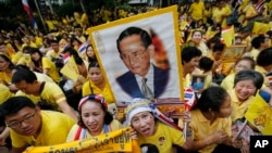 FILE - Supporters of Thailand's King Bhumibol Adulyadej, carrying portraits and banners, are seen celebarting his 87th birthday, in Bangkok, Thailand, Dec. 5, 2014.