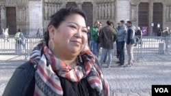 American tourist Dawn Mabalon stands in front of Notre Dame Cathedral in Paris, France, Nov. 15, 2015. (Photo - L. Bryant/VOA)
