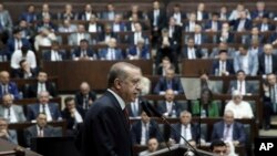 Turkey's President and the leader of ruling Justice and Development Party Recep Tayyip Erdogan addresses his supporters at the parliament in Ankara, Turkey, Tuesday, July 25, 2017. Erdogan has accused Israel of using terrorism as a pretext to take over holy sites in Jerusalem from Muslims and called on all Muslims to defend the holy sites by visiting Jerusalem at every occasion or by sending aid to Muslims there.