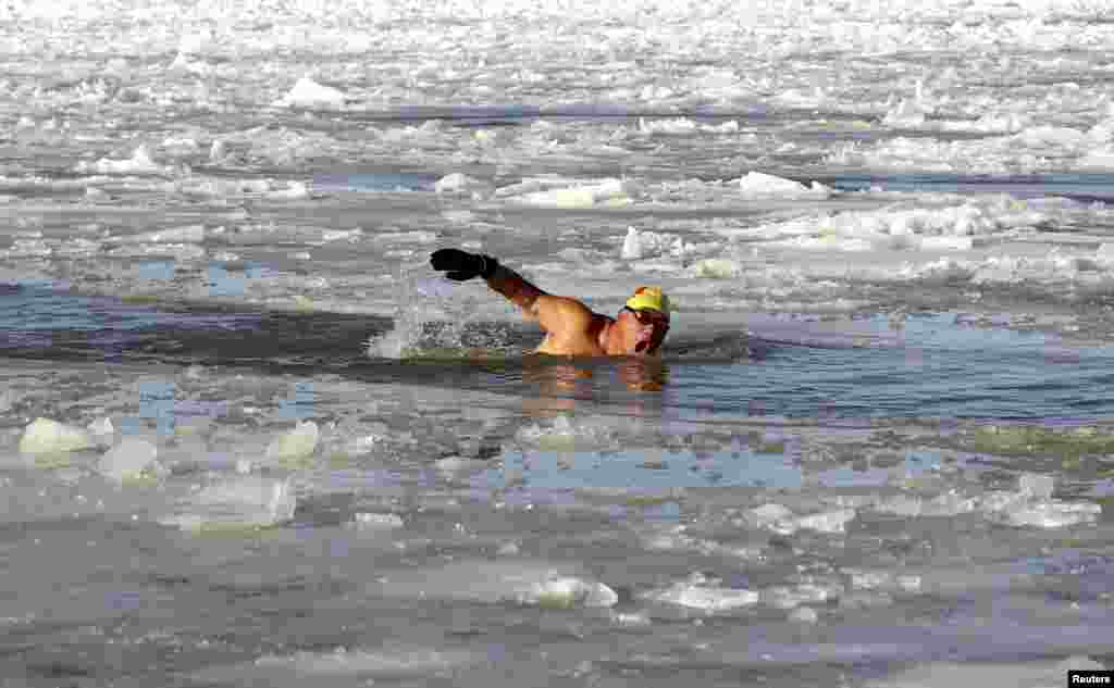 Seorang laki-laki berenang dalam air bercampur es di sungai Amur, Heihe, propinsi Heilongjiang, China, tanggal 1 November 2015.