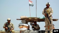 Iraqi government troops at a checkpoint in the Jurf al-Sakher area, some 50 kilometers south of Baghdad, to protect the area from further Islamic State (IS) group advancement, on May 24, 2015.