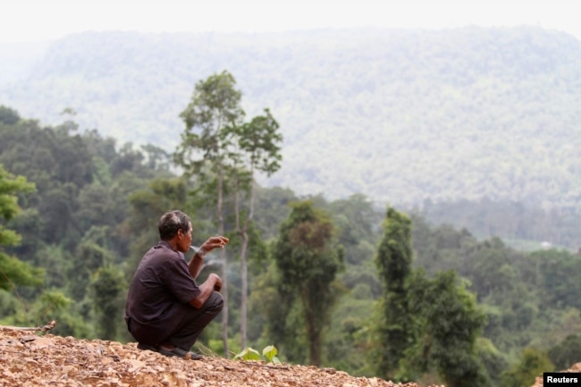 FILE - A man smokes before a commemoration ceremony in Koh Kong province May 11, 2012.