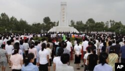 FILE - North Koreans stand together during a meeting in Pyongyang on June 15, 2012, to mark the 12th anniversary of the North-South Joint Declaration. 