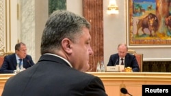 ولادیمیر پوتین رئیس جمهوری روسیه (رو به تصویر) و پترو پوروشنکو رئیس جمهوری اوکراین (پشت به تصویر)