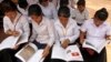 Cambodian students read a newly-delivered copy of "A History of Democratic Kampuchea" in Anlong Veng, in Uddor Mean Chey province, about 300 kilometers (185 miles) north of Phnom Penh, Cambodia, Monday, June 21, 2010. Cambodian students in the former Khmer Rouge stronghold were issued the textbook Monday that for the first time teaches the atrocities of the past, a little more than a decade after government forces captured the movement's last bastion. (AP Photo/Heng Sinith)