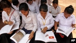 Cambodian students read a newly-delivered copy of "A History of Democratic Kampuchea" in Anlong Veng, in Uddor Mean Chey province, about 300 kilometers (185 miles) north of Phnom Penh, Cambodia, Monday, June 21, 2010. Cambodian students in the former Khmer Rouge stronghold were issued the textbook Monday that for the first time teaches the atrocities of the past, a little more than a decade after government forces captured the movement's last bastion. (AP Photo/Heng Sinith)