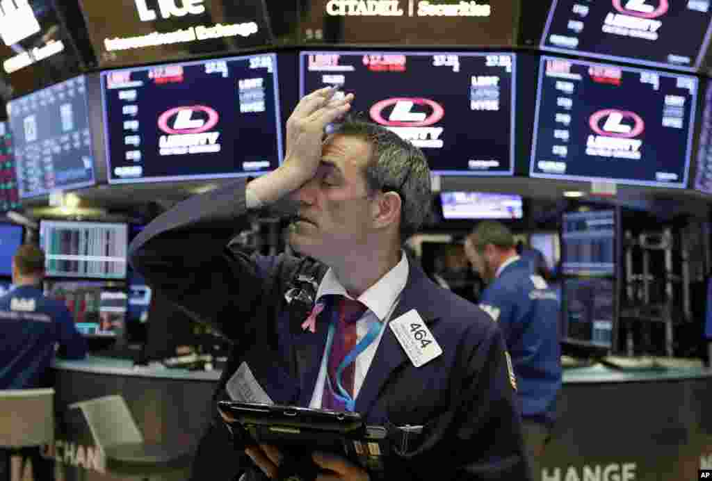 Trader Gregory Rowe works on the floor of the New York Stock Exchange as stocks opened sharply lower on Wall Street following big drops in Asia and Europe.