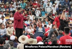 ປະທານາທິບໍດີ Nicolas Maduro, ຊ້າຍ, ກ່າວລະຫວ່າງການເຕົ້າໂຮມ ໃນການສະໜັບໜູນທ່ານ.