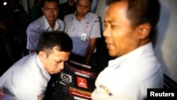 Petugas membawa kotak berisi alat perekam suara (FDR) dari pesawat AirAsia QZ8501 di kantor Komite Keselamatan Transportasi Nasional di Jakarta, (12/1).