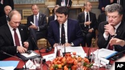 Perdana Menteri Italia Matteo Renzi (tengah) bersama Presiden Rusia Vladimir Putin (kiri) dan Presiden Ukraina Petro Poroshenko dalam pertemuan di Milan (17/10). (AP/Daniel Dal Zennaro)