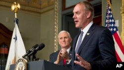 Vice President Mike Pence applauds as newly sworn in Interior Secretary Ryan Zinke addresses the crowd, March 1, 2017, in the Eisenhower Executive Office Building in Washington.