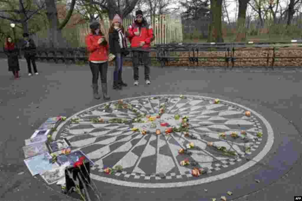 Visitors to New York's Central Park photograph the Imagine mosaic in Strawberry Fields, Tuesday, Dec. 7, 2010 in New York. Wednesday marks 30 years since John Lennon was murdered outside his New York apartment, triggering a wave of grief around the world.
