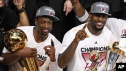 The Miami Heat's Dwyane Wade holds the the Larry O'Brien NBA Championship Trophy and LeBron James holds his most valuable player trophy after Game 5 of the NBA finals basketball series against the Oklahoma City Thunder in Miami, June 22, 2012.