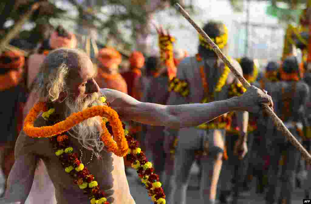 An Indian elderly naked sadhu (Hindu holy man) gestures as he takes part in a religious procession toward the Sangam area during the "royal entry" for the upcoming Kumbh Mela festival in Allahabad.