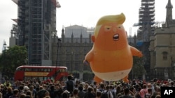 FILE - A six-meter high cartoon baby blimp of U.S. President Donald Trump is flown as a protest against his visit, in Parliament Square backdropped by the scaffolded Houses of Parliament and Big Ben in London, England, July 13, 2018. 