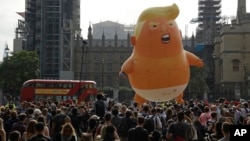 A six-meter high cartoon baby blimp of U.S. President Donald Trump is flown as a protest against his visit, in Parliament Square backdropped by the scaffolded Houses of Parliament and Big Ben in London, England, July 13, 2018. 