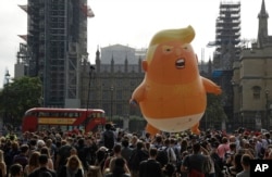 FILE - A six-meter high cartoon baby blimp of U.S. President Donald Trump is flown as a protest against his visit, in Parliament Square backdropped by the scaffolded Houses of Parliament and Big Ben in London, July 13, 2018.