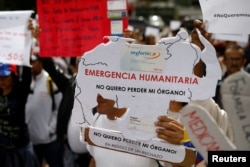 Reinaldo Olivares, a kidney transplanted patient, holds a placard with the shape of the map of Venezuela that reads, "Humanitarian emergency. I do not want to lose my organ," during a protest against medicinal shortages in Caracas, Venezuela, Feb. 8, 2018.